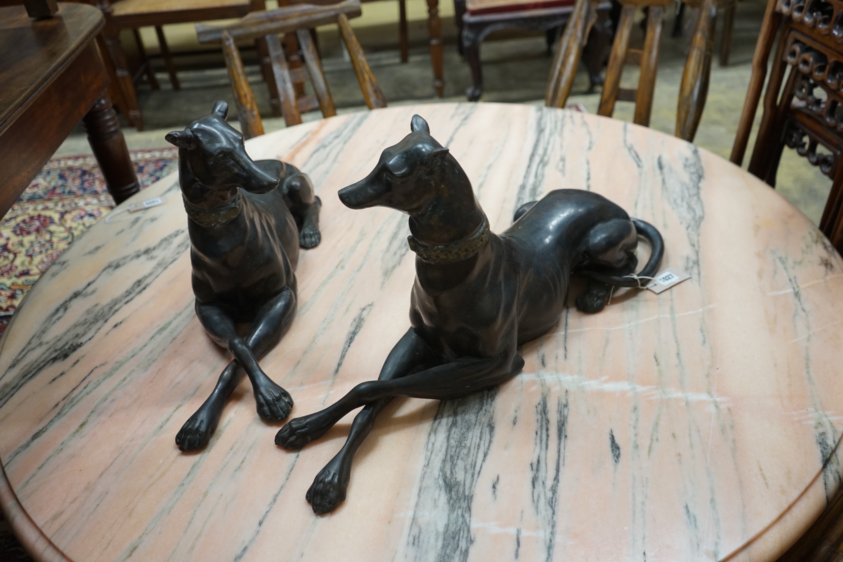 A pair of bronze recumbent greyhounds, length 67cm, height 32cm
